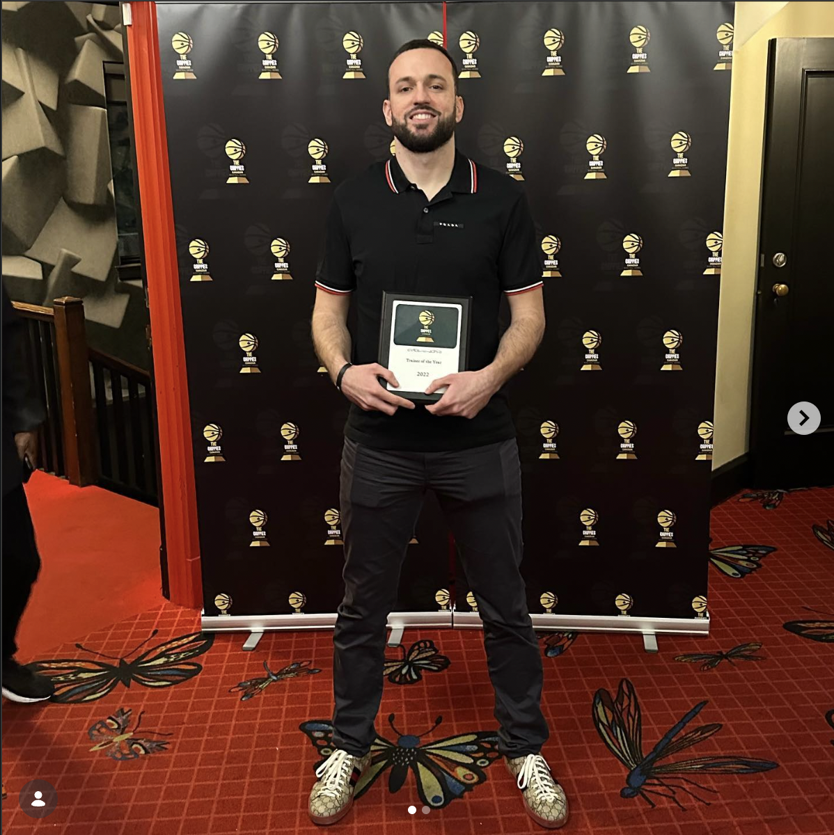 Coach holding his 2022 Trainer of the Year award