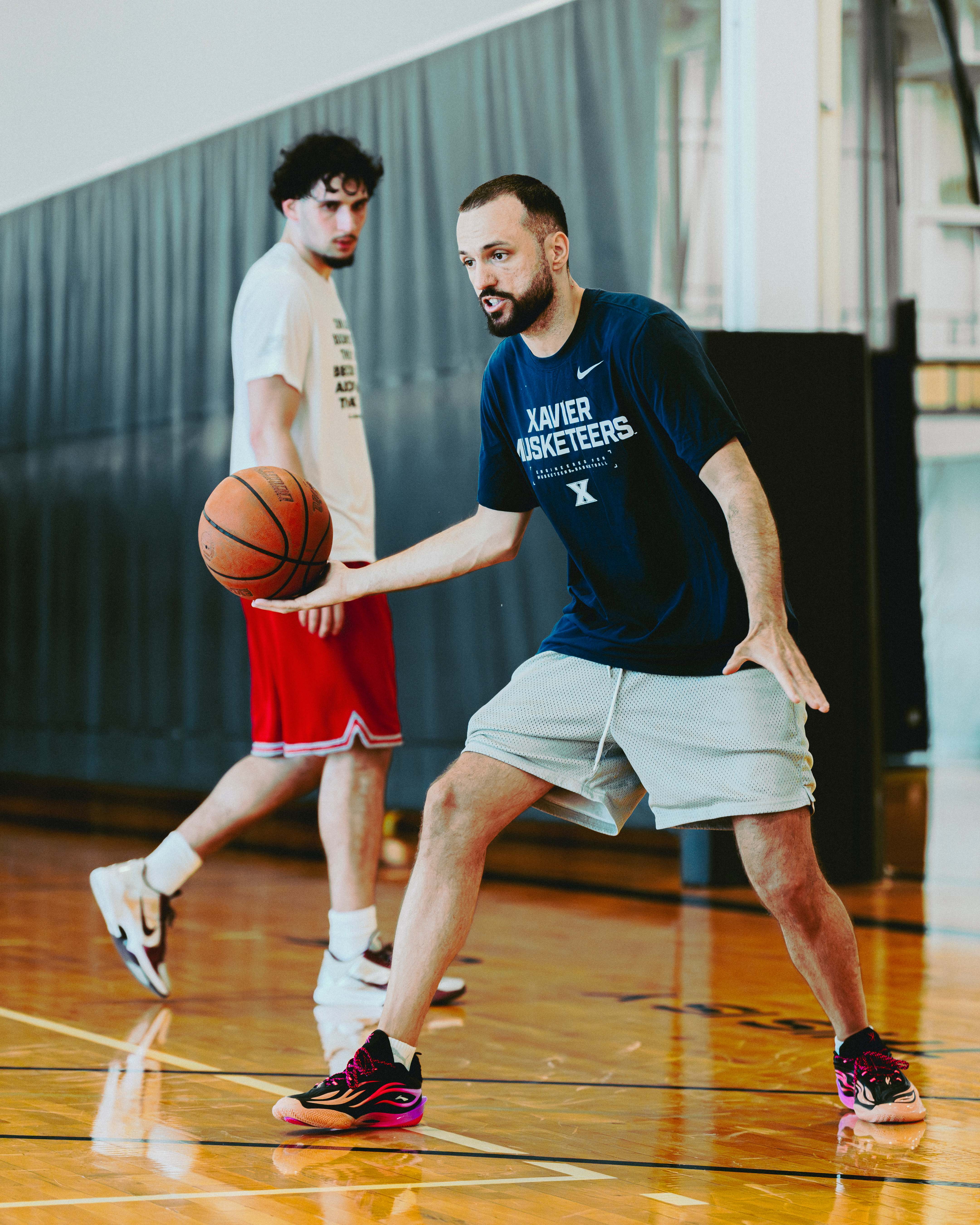 Coach demonstrating a ball-handling technique to a player